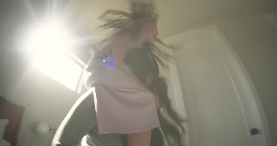 A mother spins her young daughter on her shoulders while they laugh