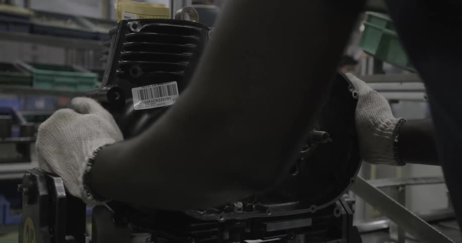 A man attaches a metal piece to a machine