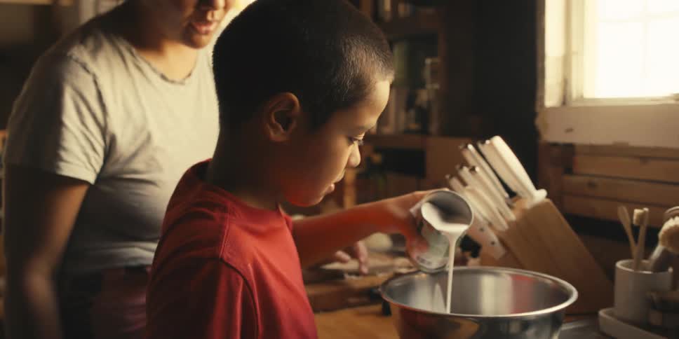 A mother and son are cooking at home