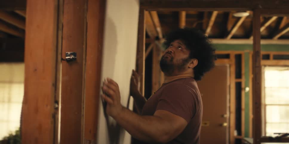 Man placing a piece of sheet rock against a wall