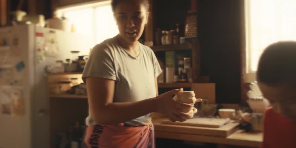 A mother and son put slices of taro root in the pot