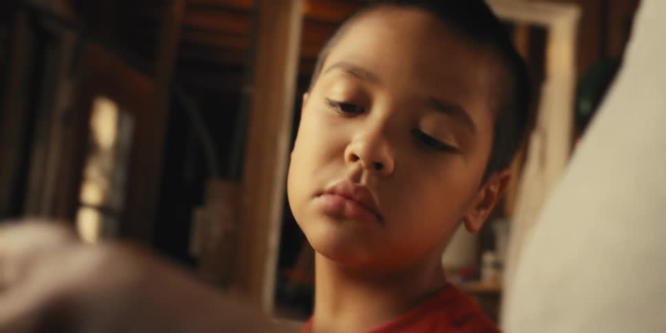 Son watches his mother perform a task at home