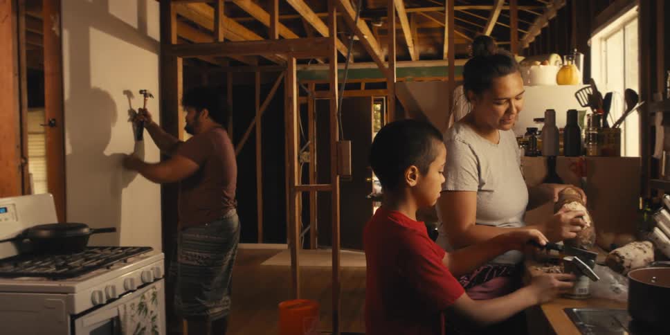 Mom tells her son to stop helping her cook and to help his dad by holding up drywall