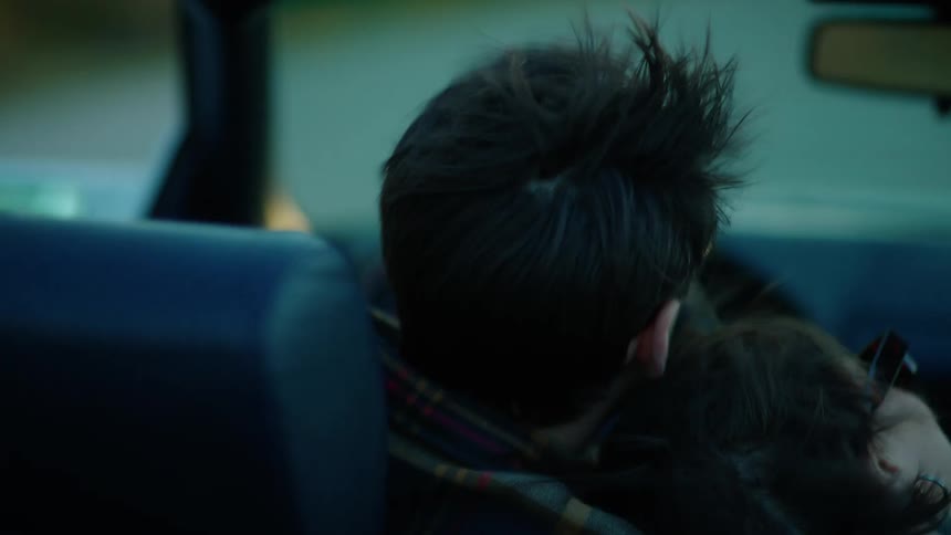 Couple leans against each other while traveling along the highway in a vehicle
