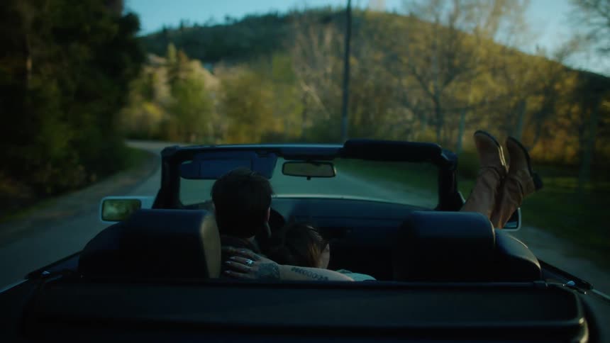 A couple ride in a convertible