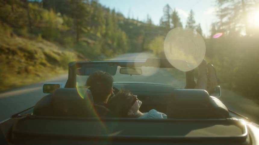 A couple ride in a car on the small road