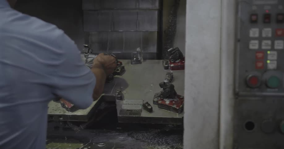 Man placing a part on a machine and then pushing  the start button