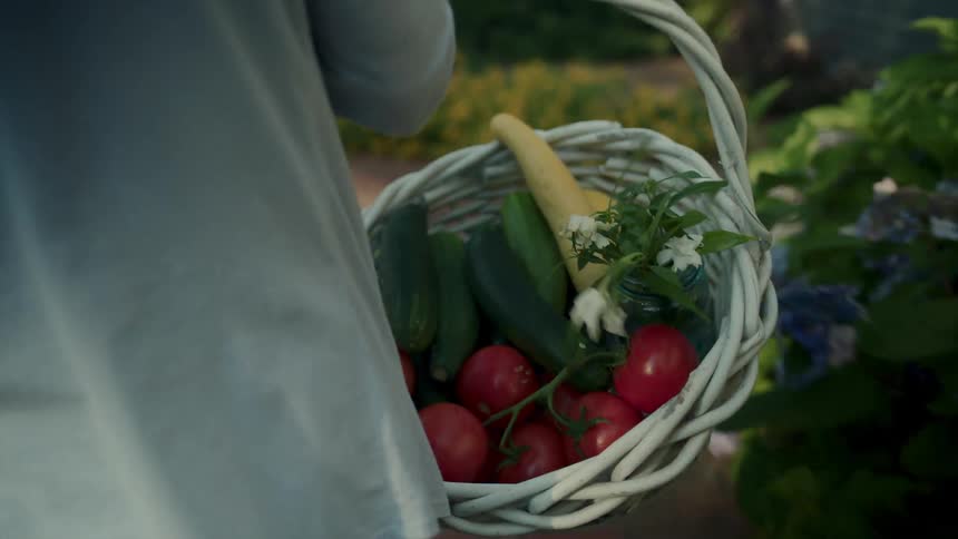 Woman with a white basket carrying vegetables