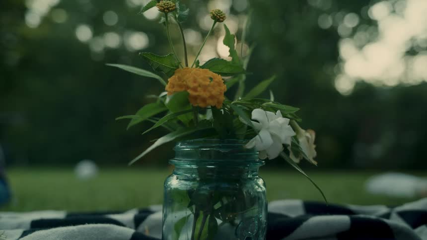 Pair of hands assembling a flower arrangement in a glass vase