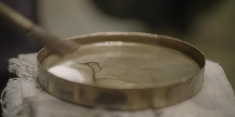 A paintbrush is dipped into paint