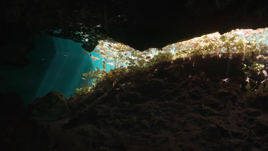 Sunlight filtering through water and illuminating an underwater cave