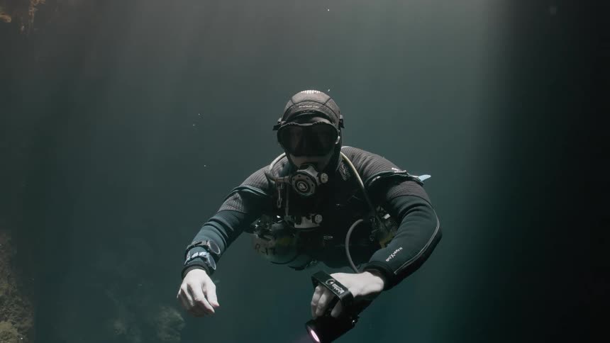 A diver is floating in the dark water