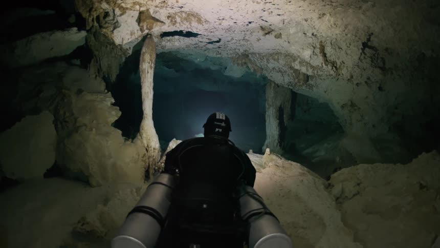 A person is scuba diving in the cave