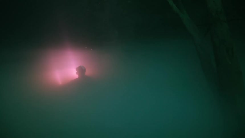 Inside the water a diver using a red light