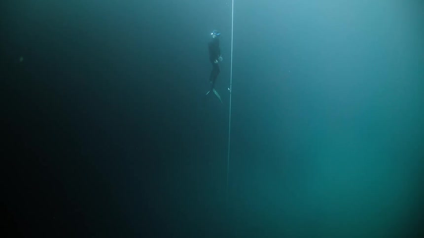 Diver submerged in the ocean rising towards the surface