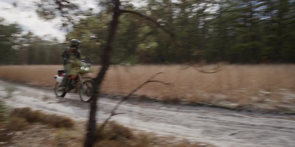 A man rides a motorcycle on a dirt road