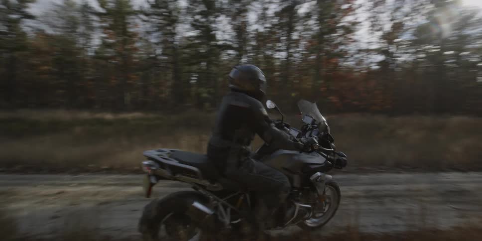 Motorcyclists travel down a dirt road