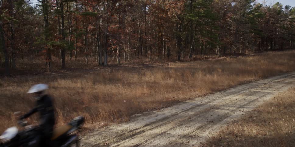 A man riding a motorcycle down a dirt trail