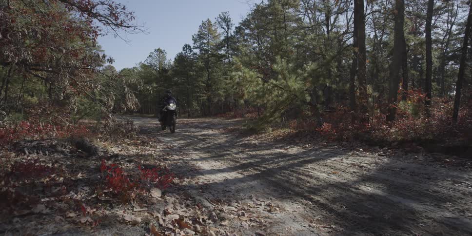 A person rides a motorcycle along a mountain road