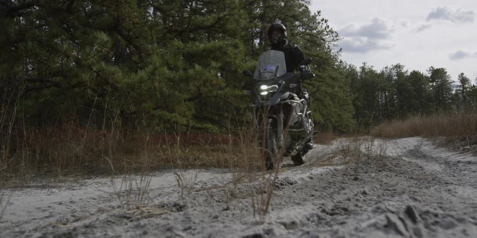 Motorcyclist riding along a dirt trail
