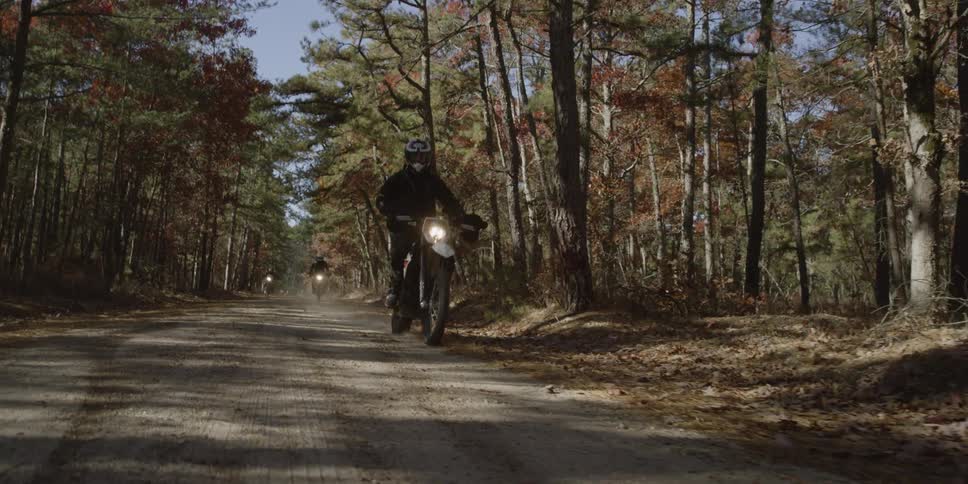 People race dirt bikes on the dirt road by the forest