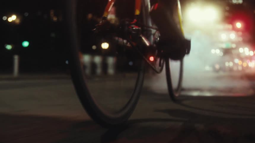 Cyclists rides along downtown street at night