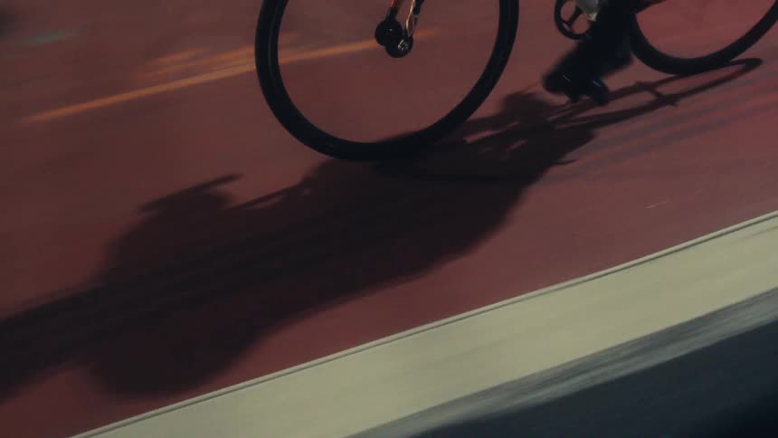 A bicycle riding along an asphalt street with several white and red stripes on the ground