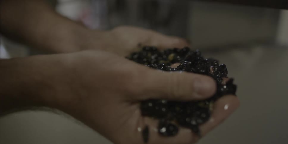 A person washes handfuls of seeds