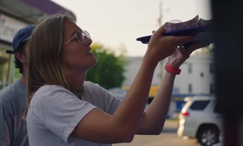 A woman is handed a tray of food from a window