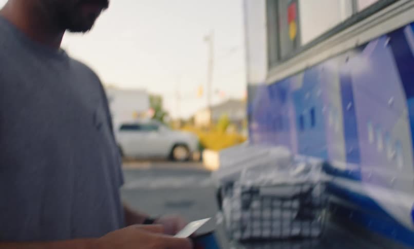 A worker in a food truck returns a credit card to a customer