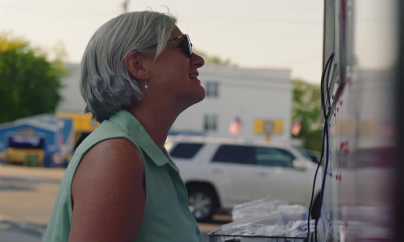 Woman talking at the window of a food truck in a parking lot