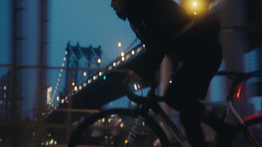 A man is cycling past the bridge
