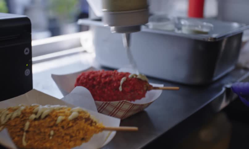 White sauce being poured over breaded chicken