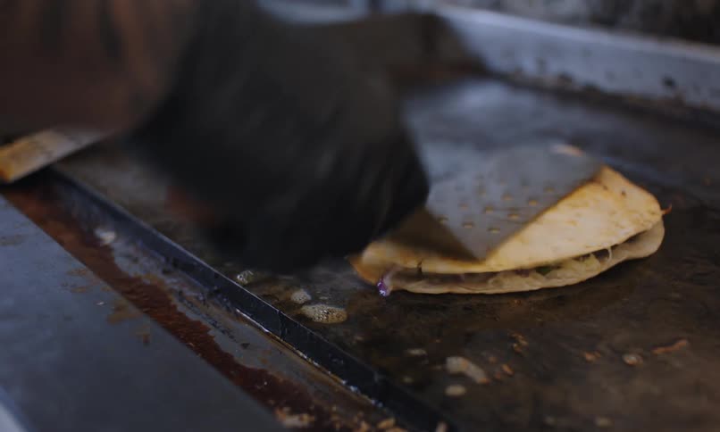 A person is cooking food on a food truck