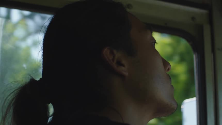 Closeup of an asian man driving a vehicle on a summer day