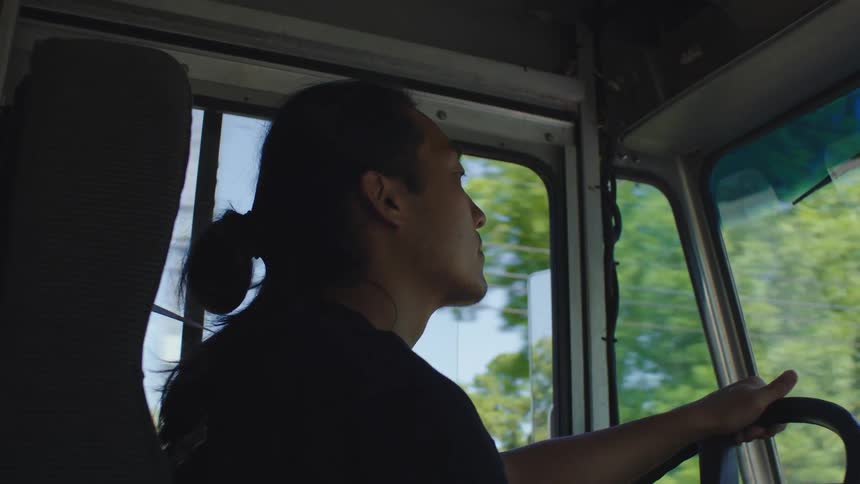 A man is driving a truck on a sunny day