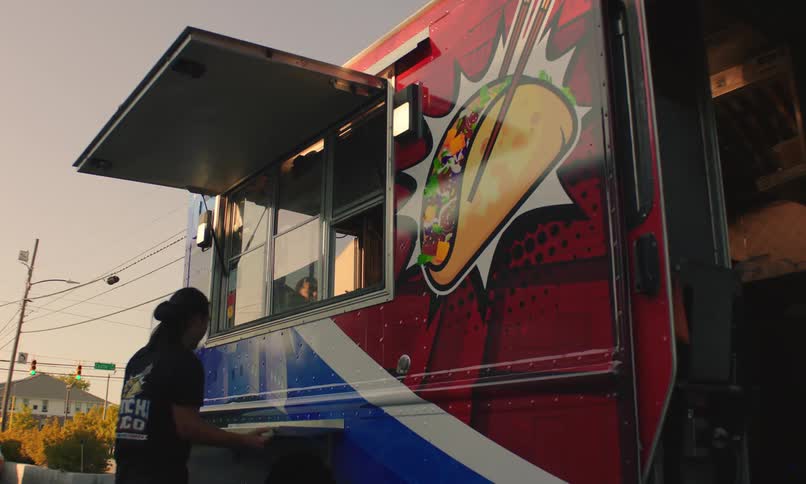 Man opening the outside window of his food truck