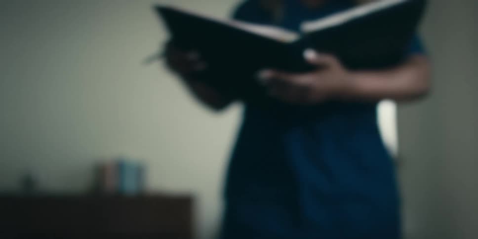 A nurse takes notes on a patient