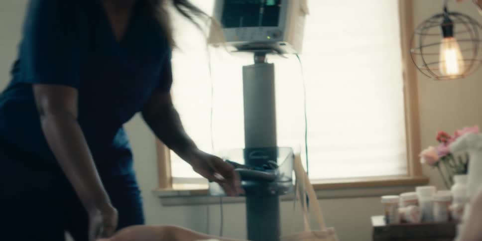 Hospital nurse administers iv to a patient lying on a hospital bed