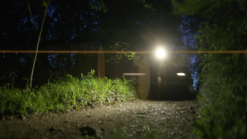 Man with a flashlight on his head running along a trail on a dark dawn