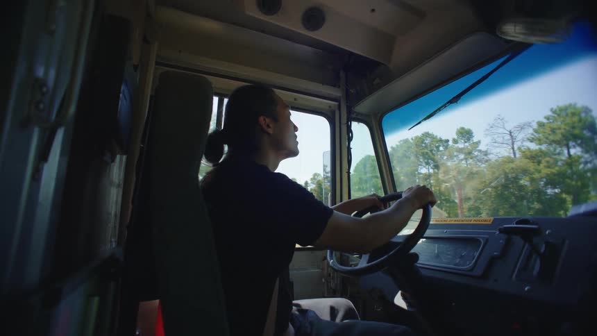 Man drives a large vehicle during the day