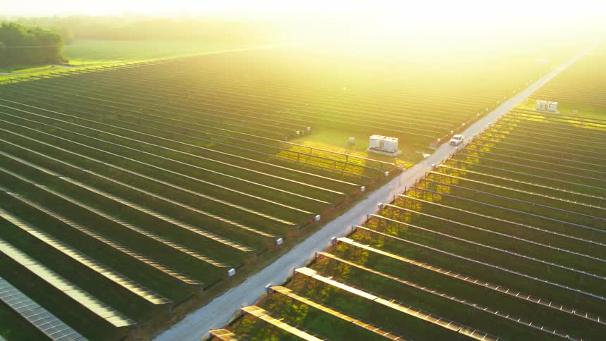 A vast solar panel farm is being shown from an aerial view