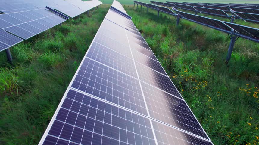 Aerial view of rows of solar panels on a solar farm in a field on the countryside at morning