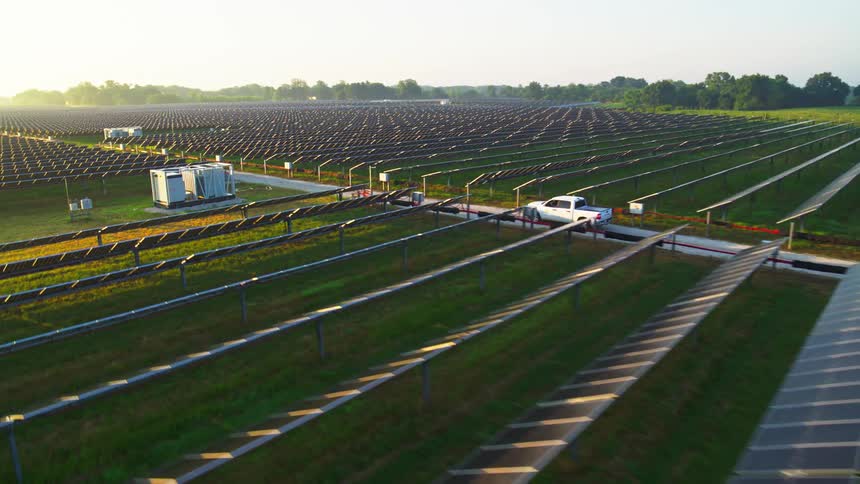 A pickup truck driving across a solar farm
