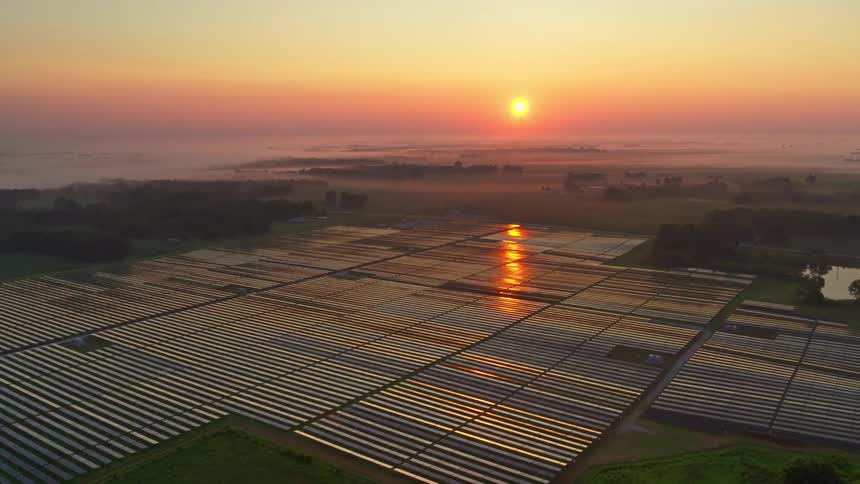 A solar farm with photovoltaic panels at sunrise