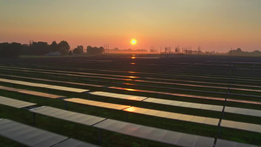 Large field of solar panels during sunset