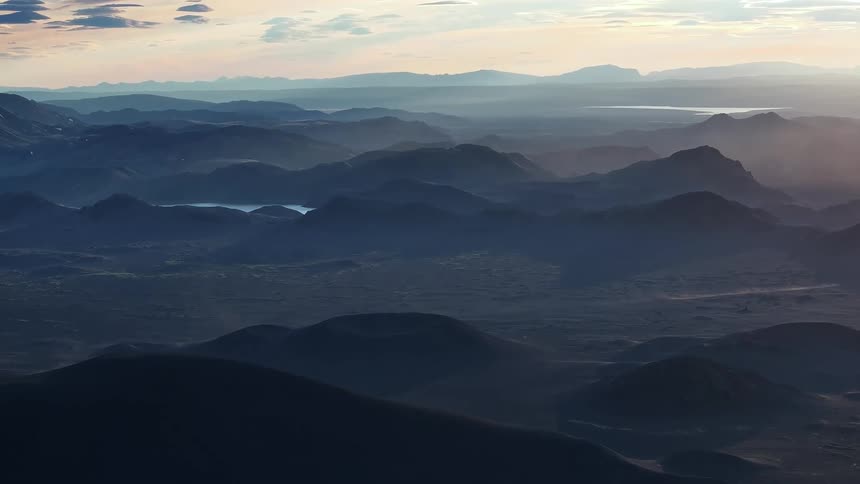 Aerial of a mountain range and valley at dusk