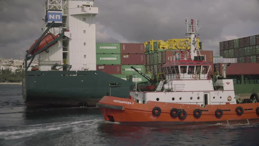 Several boats sail through the water