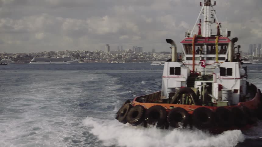 A bot sails away from a city port