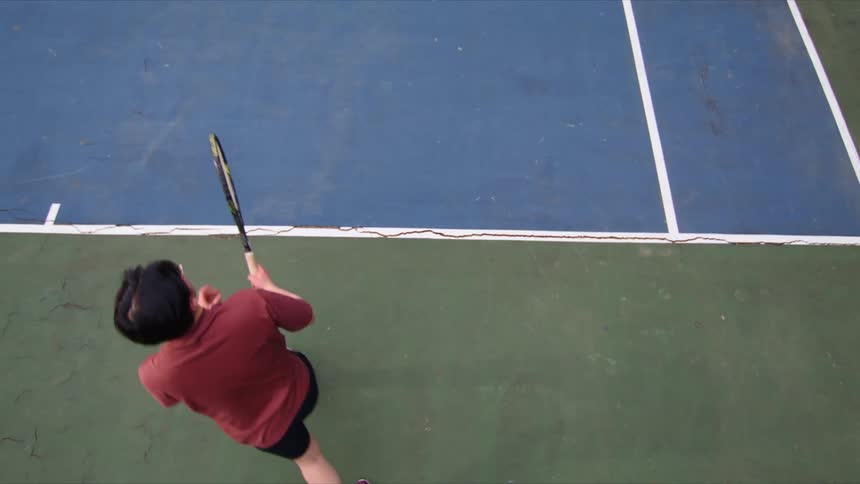 A man hits a tennis ball with a tennis racket